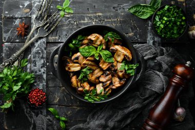 Yiyecekler. Siyah taş tabakta fesleğenli ızgara mantar. Üst Manzara. Metnin için boş yer.