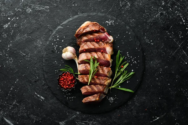 Gegrilltes Rindersteak Scheiben Mit Rosmarin Und Gewürzen Auf Schwarzem Steingrund — Stockfoto