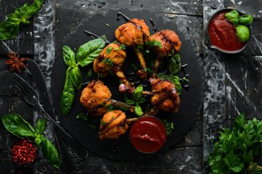 Yiyecekler. Ketçaplı tavuk kanadı ve kara taş tabakta balzamik sos. Üst Manzara. Metnin için boş yer.