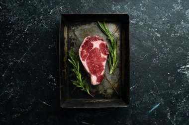 Metal bir kabın içinde biftek pirzolası. Üst Manzara. Metnin için boş yer.