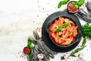 Yiyecekler. Siyah taş tabakta fesleğenli domates soslu haşlanmış karides. Üst Manzara. Metnin için boş yer.