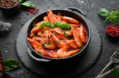 Yiyecekler. Siyah taş tabakta fesleğenli domates soslu haşlanmış karides. Üst Manzara. Metnin için boş yer.