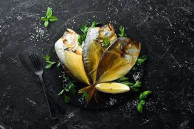 Siyah taş tabakta maydanozlu füme deniz balığı Vomer. Üst Manzara. Metnin için boş yer.