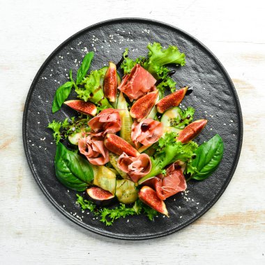 Prosciutto, salatalık ve incirli yeşil salata. Yiyecekler. Üst Manzara. Metnin için boş yer.