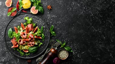 Prosciutto, salatalık ve incirli yeşil salata. Yiyecekler. Üst Manzara. Metnin için boş yer.