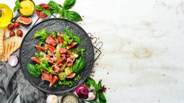 Prosciutto, salatalık ve incirli yeşil salata. Yiyecekler. Üst Manzara. Metnin için boş yer.