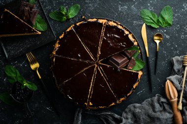 Siyah bir tabakta lezzetli çikolatalı pasta. Üst Manzara. Kırsal biçim.