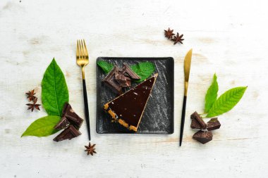 Siyah bir tabakta lezzetli çikolatalı pasta. Üst Manzara. Kırsal biçim.