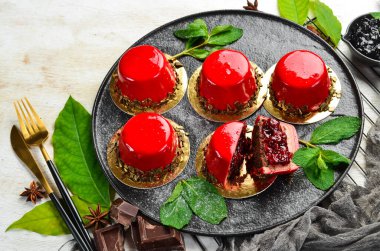 Vişneli kremalı tatlı ve siyah taş tabakta nane. Üst Manzara. Kırsal biçim.