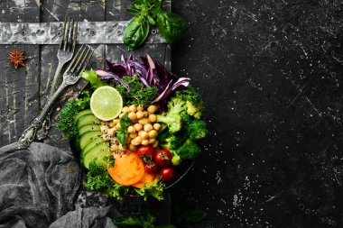 Vejetaryen Buda kasesi: Siyah taş tabakta nohut, brokoli, domates ve salatalık. Yiyecekler. Üst Manzara. Metnin için boş yer.