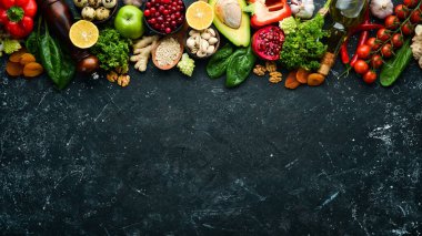 Gıda geçmişi: Bir dizi sağlıklı ve temiz yiyecek - sebze, meyve, balık, et, fındık ve sebze. Siyah taştan bir arka planda. Üst Manzara. Boş kopyalama alanı.