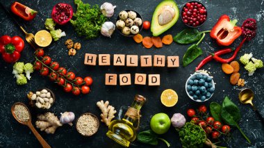Gıda geçmişi: Bir dizi sağlıklı ve temiz yiyecek - sebze, meyve, balık, et, fındık ve sebze. Siyah taştan bir arka planda. Üst Manzara. Boş kopyalama alanı.