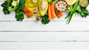 E vitamini bakımından zengin yiyecek seti: balkabağı, brokoli, kurutulmuş kayısı, maydanoz, avokado ve sebze. Üst Manzara. Kırsal biçim.