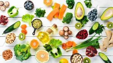 E vitamini bakımından zengin yiyecek seti: balkabağı, brokoli, kurutulmuş kayısı, maydanoz, avokado ve sebze. Üst Manzara. Kırsal biçim.