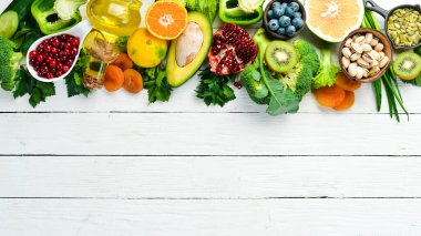 Yiyecek arka planı: beyaz ahşap arka planda meyve, sebze ve böğürtlen. Üst Manzara. Kırsal biçim.