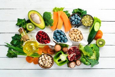 Yiyecek arka planı: beyaz ahşap arka planda meyve, sebze ve böğürtlen. Üst Manzara. Kırsal biçim.