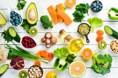 Yiyecek arka planı: beyaz ahşap arka planda meyve, sebze ve böğürtlen. Üst Manzara. Kırsal biçim.