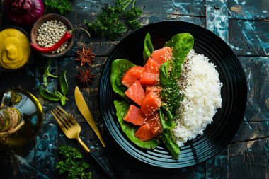 Kırmızı balıklı pilav, yeşil fasulye ve siyah tabakta ıspanak. Diyet olsun. Üst Manzara. Metin için boş alan.