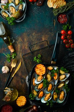 Maydanoz ve limonlu sarımsak soslu haşlanmış midye. Deniz ürünleri. Siyah taştan bir arka planda.