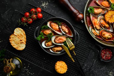 Domates soslu midye, sarımsak, maydanoz ve limon. Deniz ürünleri. Metin için boş alan. Taş bir arka planda.