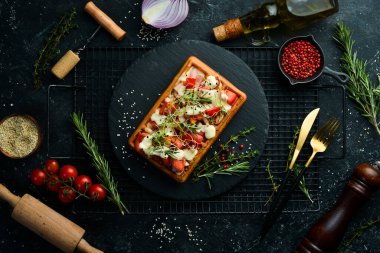 Belçika waffleları: domuz pastırması, domates ve mikroyeşillik. Kahvaltıda. Siyah taştan bir tabakta.