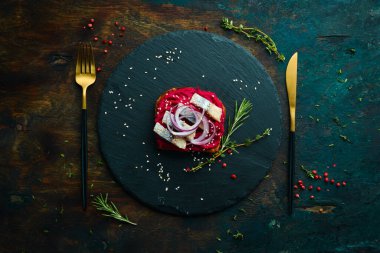 Pancar humusu, ringa balığı ve soğanlı sandviç. Kahvaltıda. Siyah taştan bir tabakta.