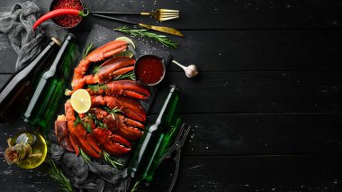 Bira partisi. Bira, abur cubur ve siyah arka planda ıstakoz pençeleri. Kırsal tarzda. Deniz ürünleri lezzetleri..