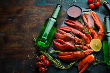 Bira partisi. Bira, abur cubur ve siyah arka planda ıstakoz pençeleri. Kırsal tarzda. Deniz ürünleri lezzetleri..
