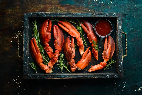 Lobster claws. Boiled crustacean claws on a black stone background. Rustic style.