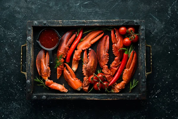 Lobster claws. Boiled crustacean claws on a black stone background. Rustic style.