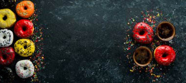 Siyah taş bir masada bir fincan kahveyle vişneli tatlı çörek. Üst görünüm.