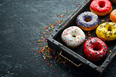 Tahta bir kutuda renkli tatlı çörekler. Üst Manzara. Düz Yat.