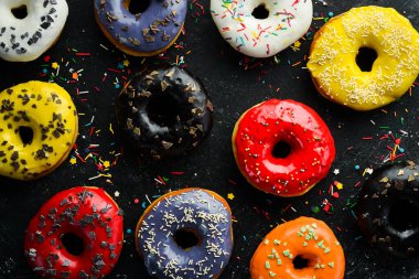 Siyah arka planda renkli tatlı çörek. Üst Manzara. Kırsal biçim.