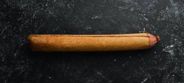 Biberiyeli lezzetli salam ve siyah arka planda baharatlar. Üst Manzara. Kırsal biçim.