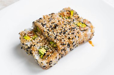 Geleneksel suşi ruloları ve susamlı maki, avokado ve balık. Japon yemeği. Üst Manzara. Beyaz bir arkaplanda.