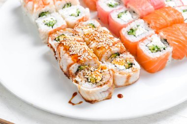 Asya mutfağı. Büyük bir tabak dolusu suşi rulosu. Üst Manzara. Beyaz bir arkaplanda.