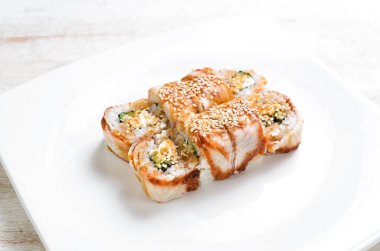 Geleneksel Japon suşisi beyaz tabakta yuvarlanır. Üst Manzara. Asya yemekleri. Beyaz bir arkaplanda.