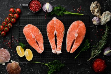 Baharatlı ve otlu somon bifteği. Hazırlık. Karanlık bir arka planda. Üst görünüm.