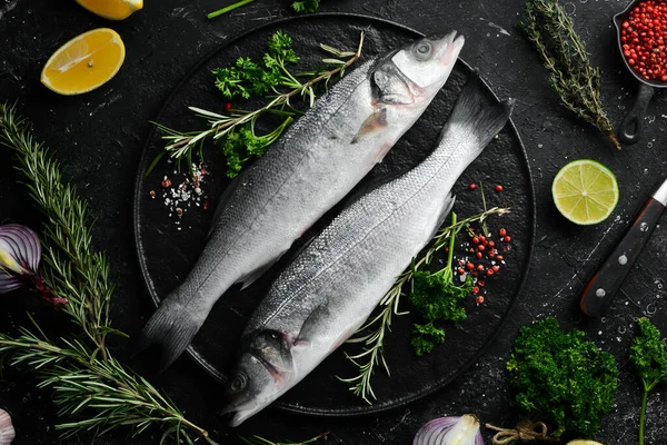 Dois Peixes Robalo Com Especiarias Uma Placa Pedra Preta Num — Fotografia de Stock