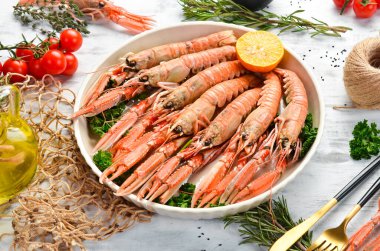 Maydanozlu kaynamış Langoustines ve bir tabak baharat. Beyaz ahşap arka planda Norveç ıstakozu. Üst Manzara. Boş kopyalama alanı.