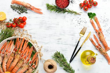 Maydanozlu kaynamış Langoustines ve bir tabak baharat. Beyaz ahşap arka planda Norveç ıstakozu. Üst Manzara. Boş kopyalama alanı.