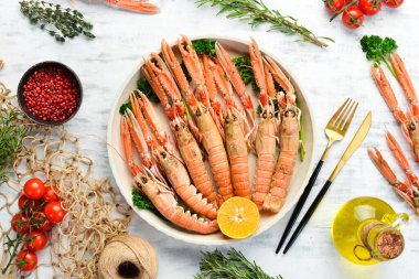 Maydanozlu kaynamış Langoustines ve bir tabak baharat. Beyaz ahşap arka planda Norveç ıstakozu. Üst Manzara. Boş kopyalama alanı.