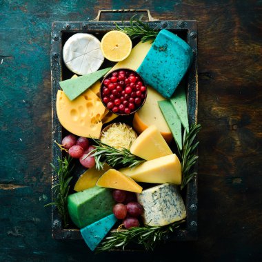 Ahşap bir kutuda abur cuburlu büyük peynir seti. Siyah taştan bir arka planda. Boş kopyalama alanı.