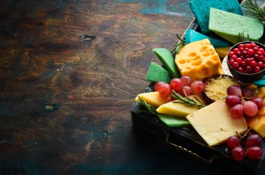 Ahşap bir kutuda abur cuburlu büyük peynir seti. Siyah taştan bir arka planda. Boş kopyalama alanı.