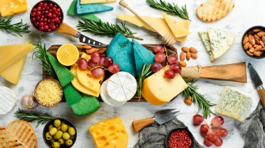 Tahta üzerinde peynir dilimleri: Brie, mavi peynir, parmesan ve maasdam. Bedava fotokopi. Üst görünüm.