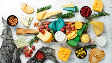 Tahta üzerinde peynir dilimleri: Brie, mavi peynir, parmesan ve maasdam. Bedava fotokopi. Üst görünüm.