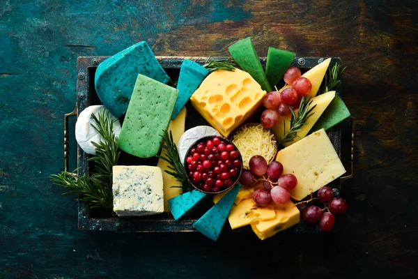 Ahşap bir kutuda abur cuburlu büyük peynir seti. Siyah taştan bir arka planda. Boş kopyalama alanı.