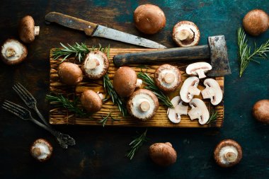 Tahtada kesilmiş taze şampiyon mantarları. Kırsal tarzda. Üst görünüm.