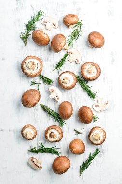 Beyaz ahşap arka planda taze şampiyon mantarları. Organik yiyecekler. Kırsal tarzda. Üst görünüm.