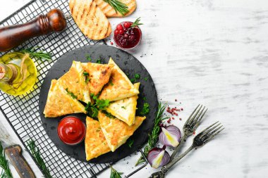 Asya yemekleri. Samsa, tavuk ve peynirli, ketçaplı, siyah taştan bir tabakta. Kırsal tarzda. Üst görünüm.